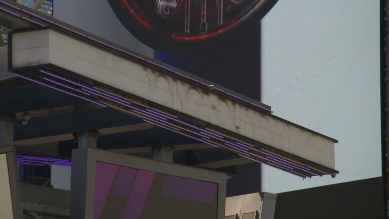 The outline of removed lettering can be seen, highlighted by remaining dirt on a large metal canopy at the soon to be former Yonge-Dundas Square.