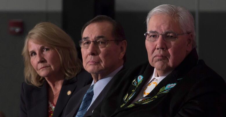 The three TRC commissioners are pictured seated closely to one another.