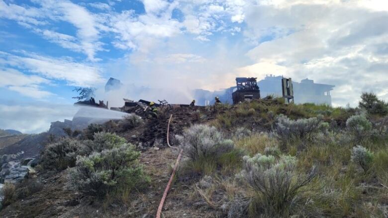 Smoke and fire equipment on sage-covered hill