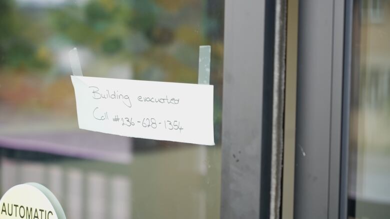 A note on a building door reads, 'Building evacuated.'