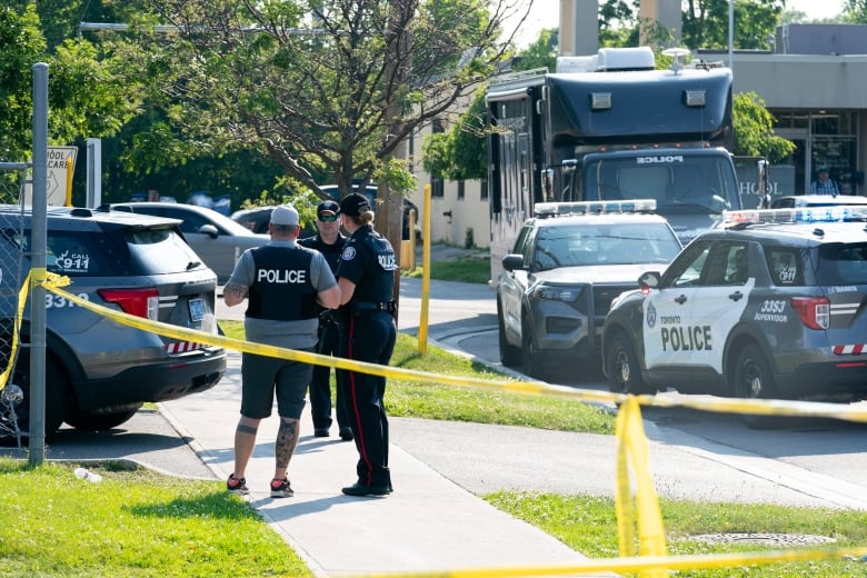 Toronto police officers investigate after three adults died in the lobby of an office space in Toronto, Monday, June 17, 2024. Police responded to reports of gunshots in an area near a school and a daycare. THE CANADIAN PRESS/Arlyn McAdorey