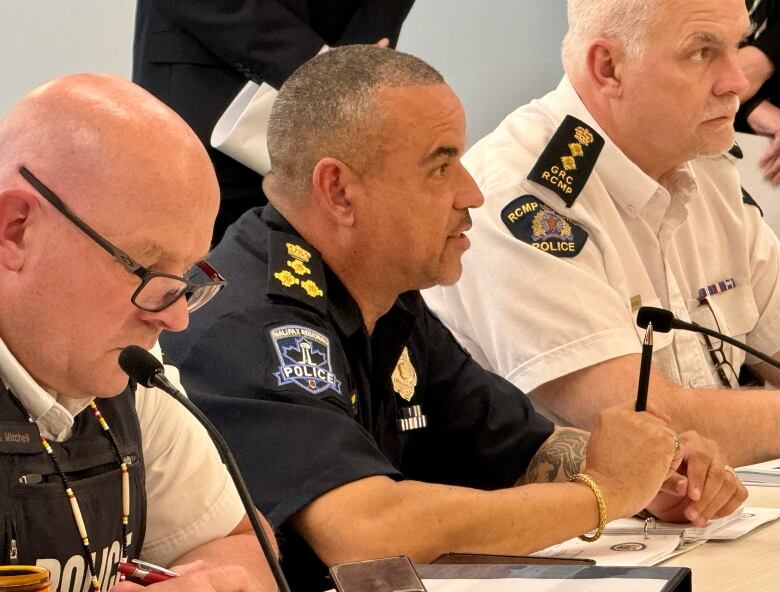 a man wearing a navy Halifax Police uniform speaks into a microphone  