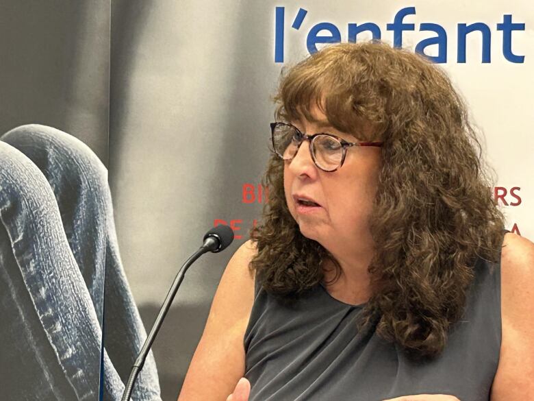 Woman speaking at microphone. 