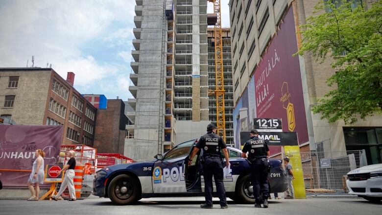 cops and cop car in front of building under construction