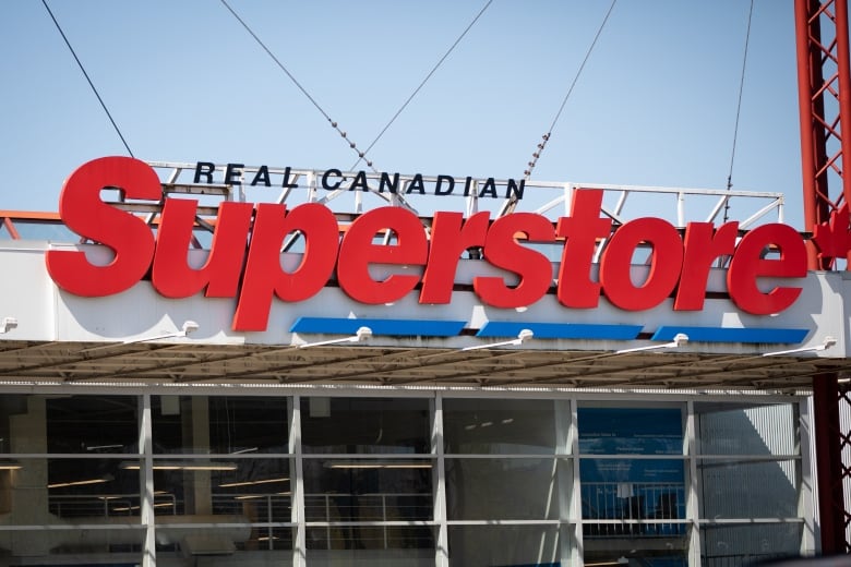 A closeup shows the exterior of a building with a sign reading 