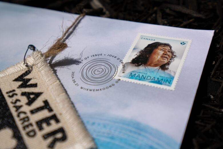 a photo of Josephine Mandamin stamp with water is sacred fabric. 