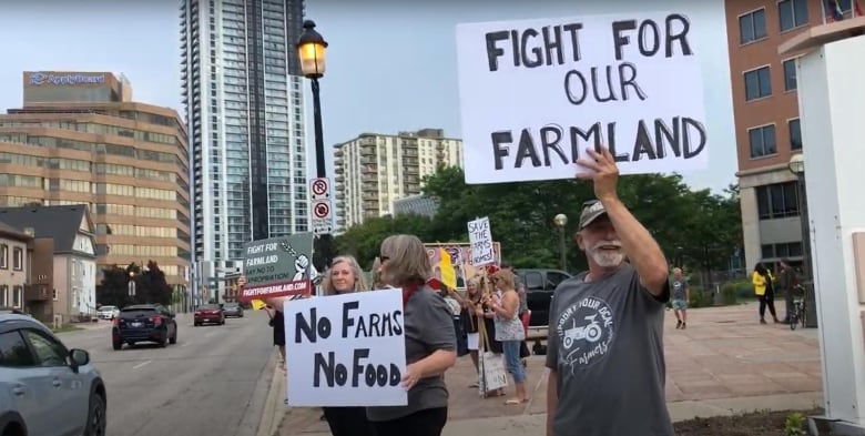 people with signs next to a street. 