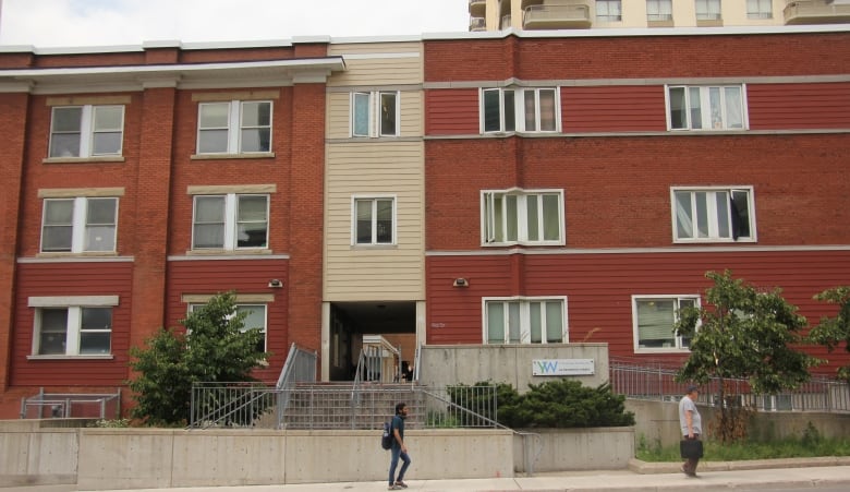 Red brick building with tan siding