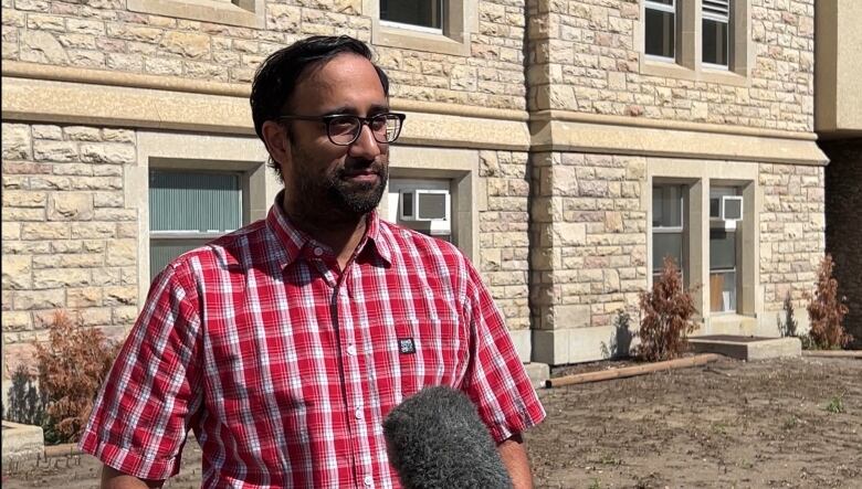 A person talking in front of a building.