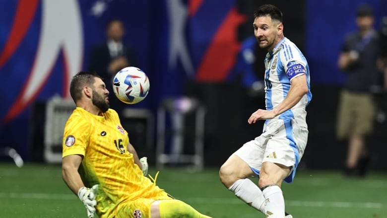 A men's goalkeeper makes a save against an attacker.