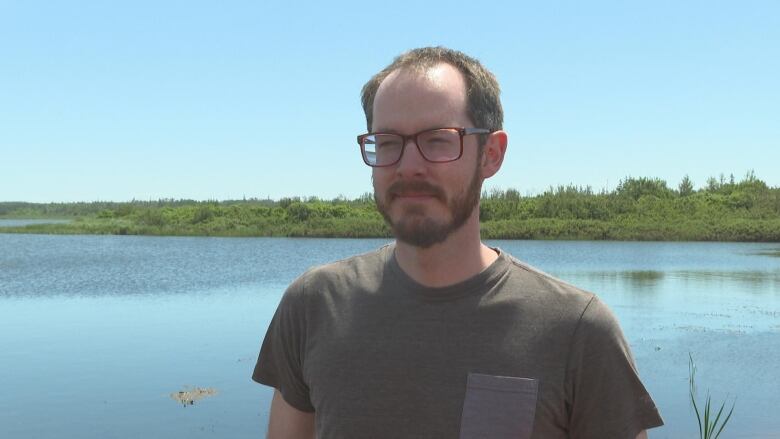 Man standing in front of body of water. 