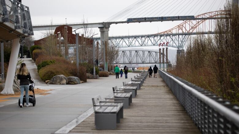 A riverside boardwalk path with bridges in the distance.