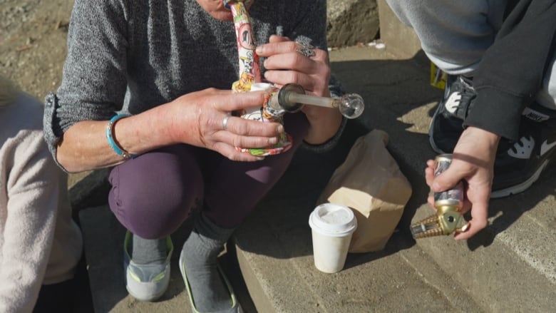 A person uses a bong and implements to smoke drugs.