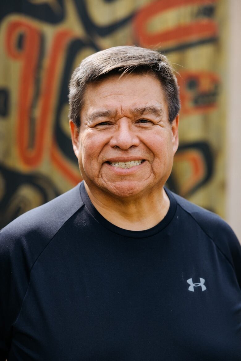 An Indigenous man smiles into the camera.