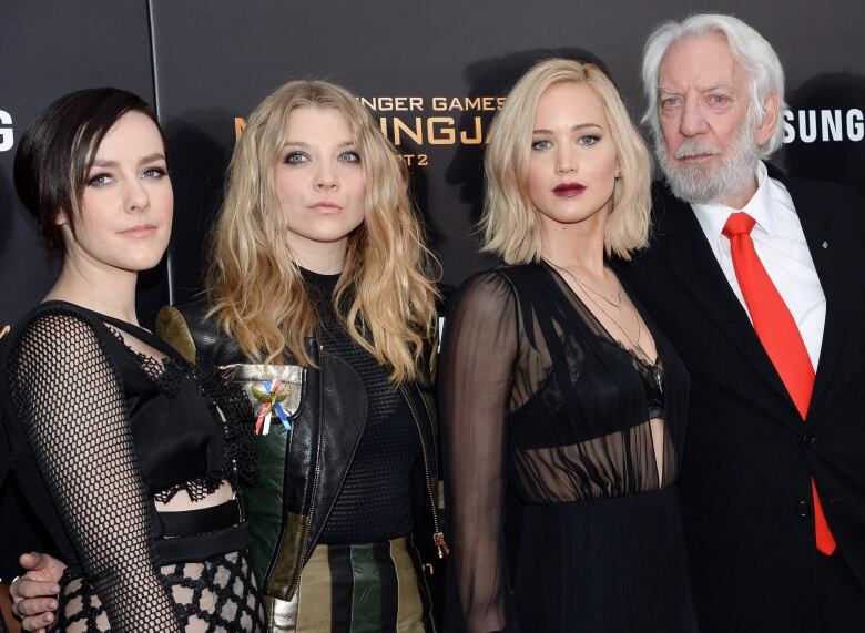 Four actors dressed in formal wear  three woman and one man  attend a movie premiere. Donald Sutherland is on the far right of the photo.