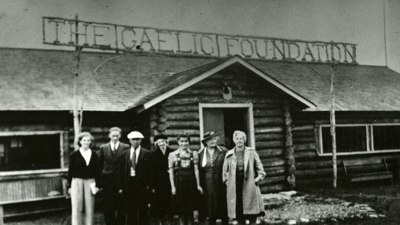 A black and white photo from 1940 of seven indivduals standing in front of a building that says The Gaelic Foundation 