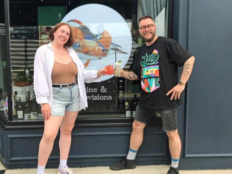 A man and a woman cheers outside of a restaurant