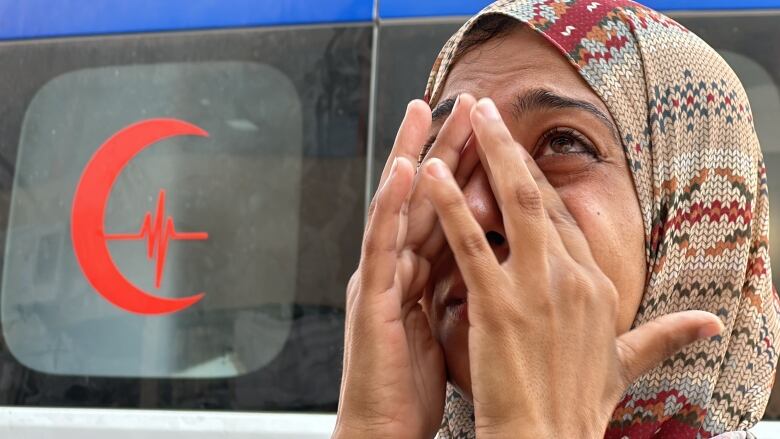 A woman wipes tears from her eyes.