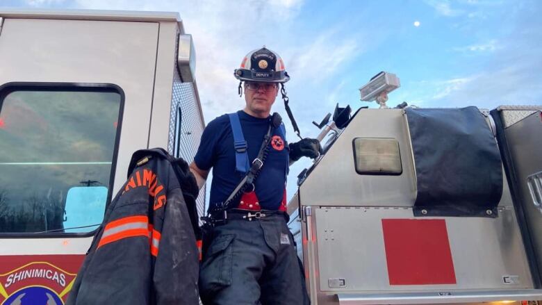 A fireman in uniform on board a fire truck.