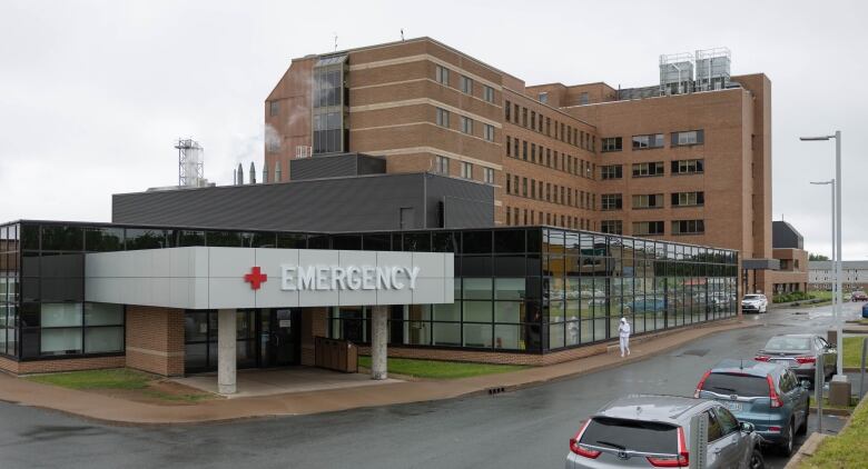 A person walks by the outside of a hospital.