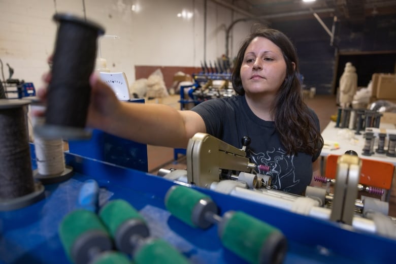 Sara Gennaro works on a machine at Taproot Fibre Lab's facility in Port Williams, where Taproot is planning to operate a wool pellet mill starting this summer.