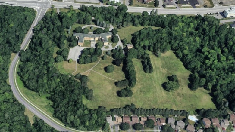 An aerial image of a building surrounded by greenspace