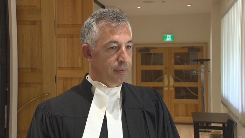 A man in lawyers robes with short grey hair.