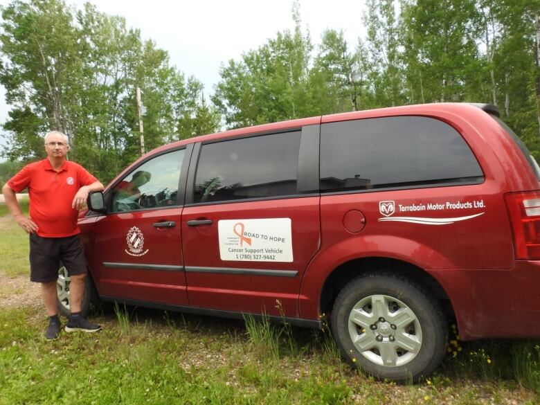 Man poses beside Road to Hope van.