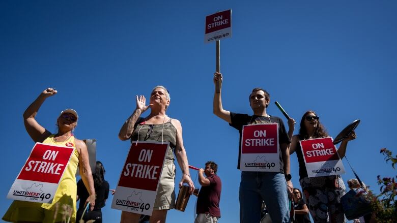 Workers wear signs that say 