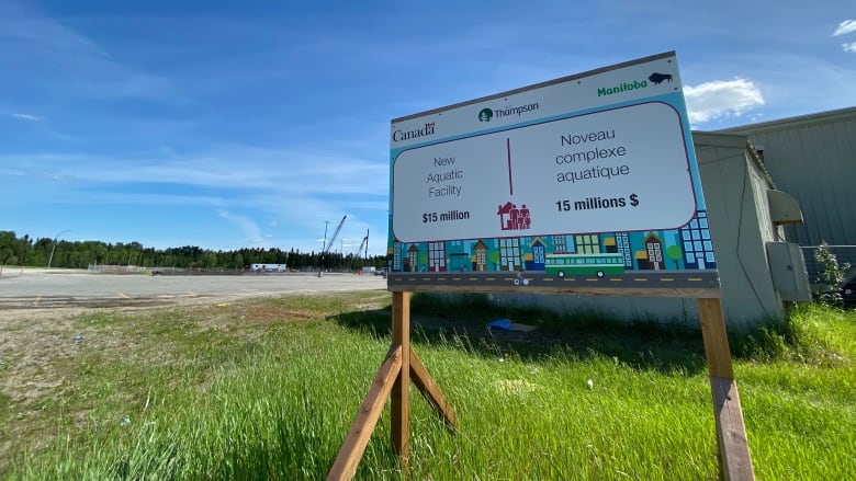 A sign that says new aquatic facility sits in the grass.