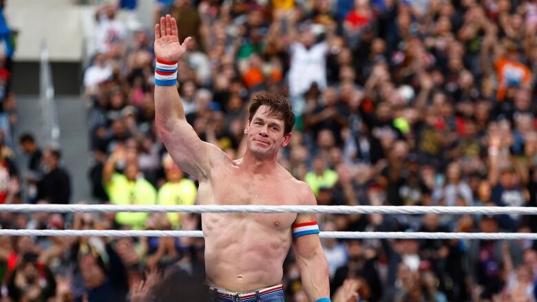 A person gestures in a professional wrestling ring.