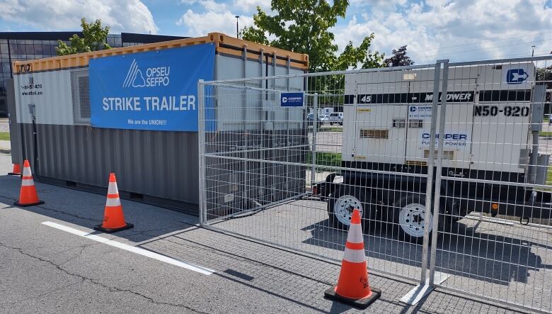 A strike trailer is surrounded by pylons.