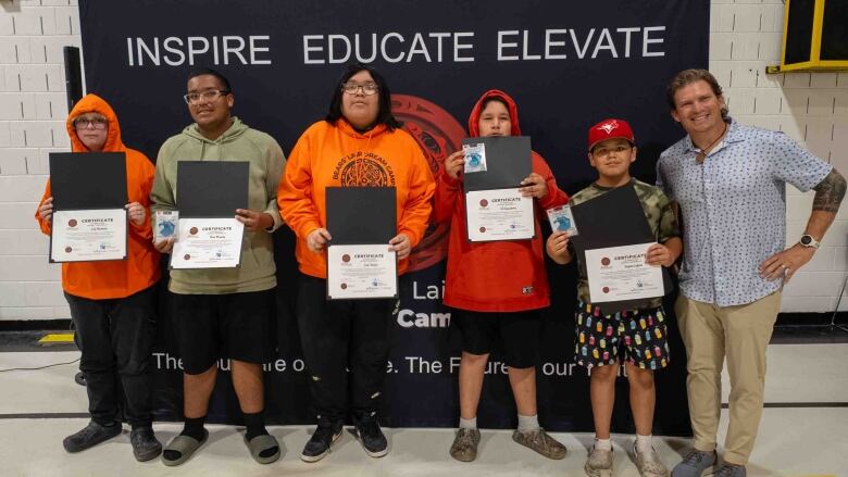 A group photo of youth holding certificates of completion. 