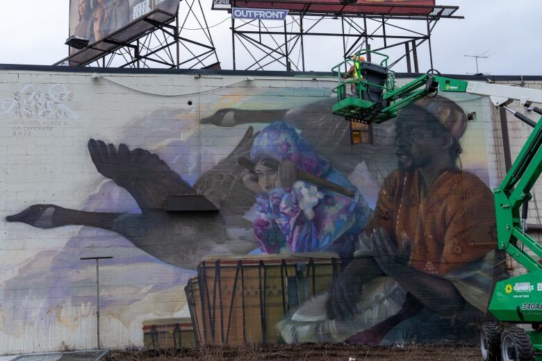 Artist Moises Frank, also known as 'Luvs,' worked with STEPS and the Eglinton Hill BIA to create Sharing Stories of Migration, a mural at Keele St & Eglinton Ave W.