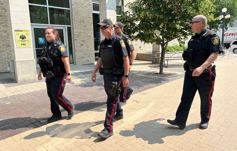 Four officers walk the foot patrol in summer