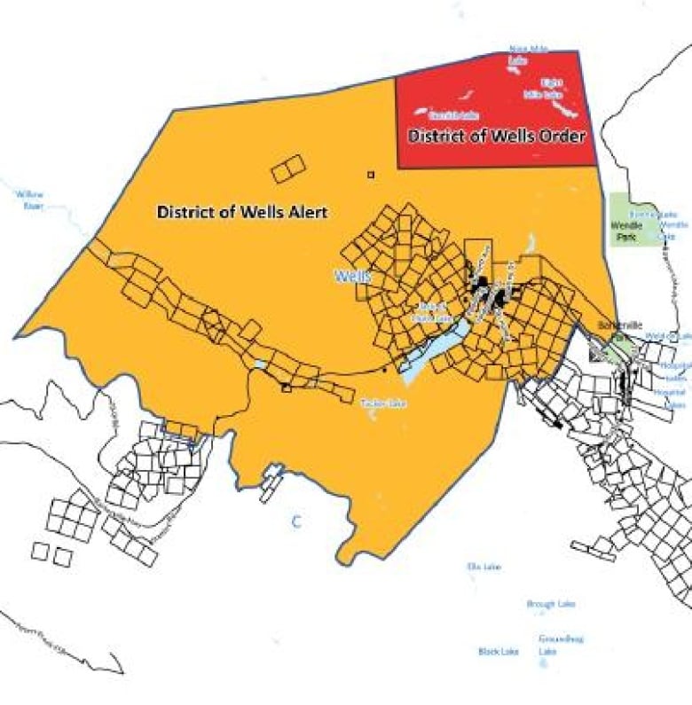 A map shows parts of the District of Wells under evacuation order in red and other parts under evacuation alert in yellow.