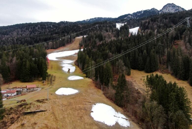 A drone picture shows the green Kandahar downhill, with small patches of snow. The Ski World Cup race was cancelled due to a lack of snow, in Garmisch-Partenkirchen, Germany, January 12, 2023.