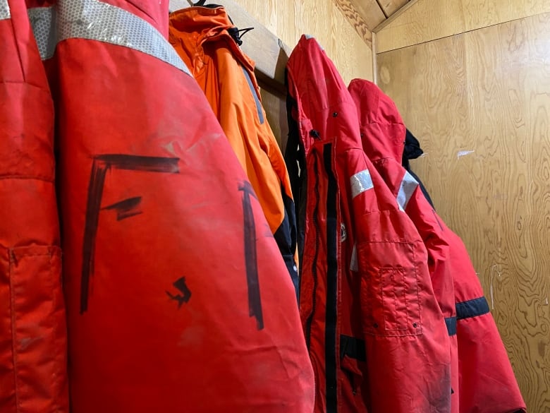 A wall of jackets in a storage room.