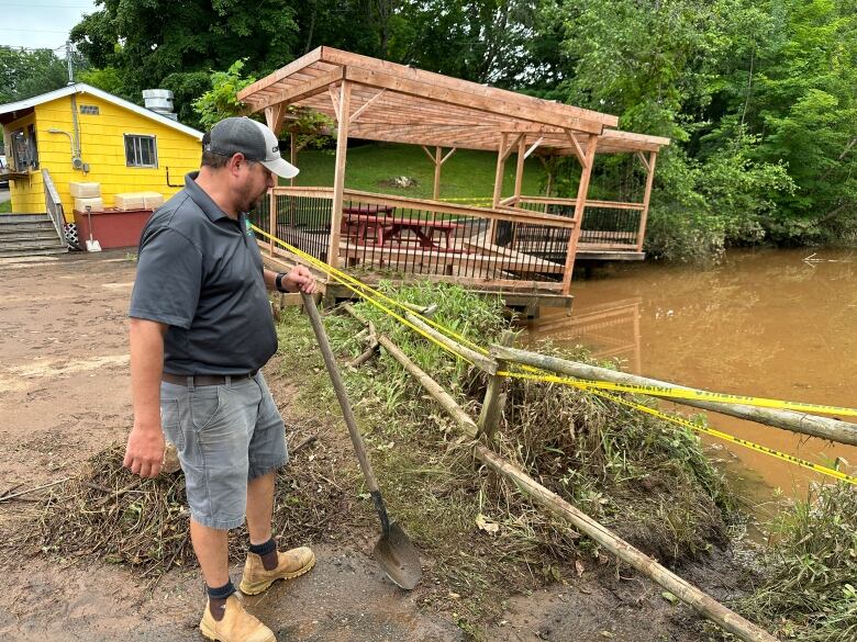 A manager of a farm market looks at damage caused by a flash flood.