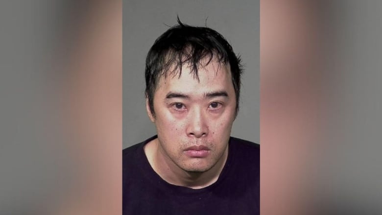 mugshot of an Asian man with short hair wearing a black tee shirt