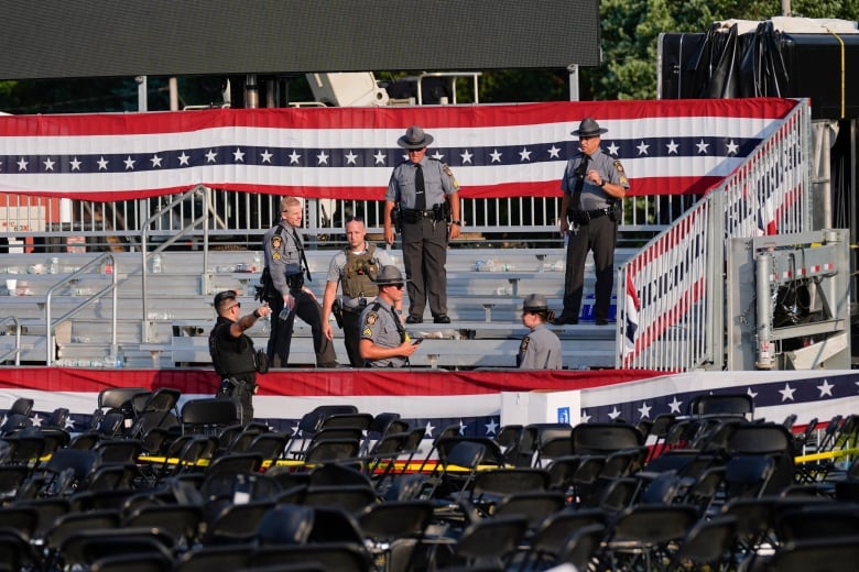 Law enforcement father on an empty bleacher at an outdoor event.