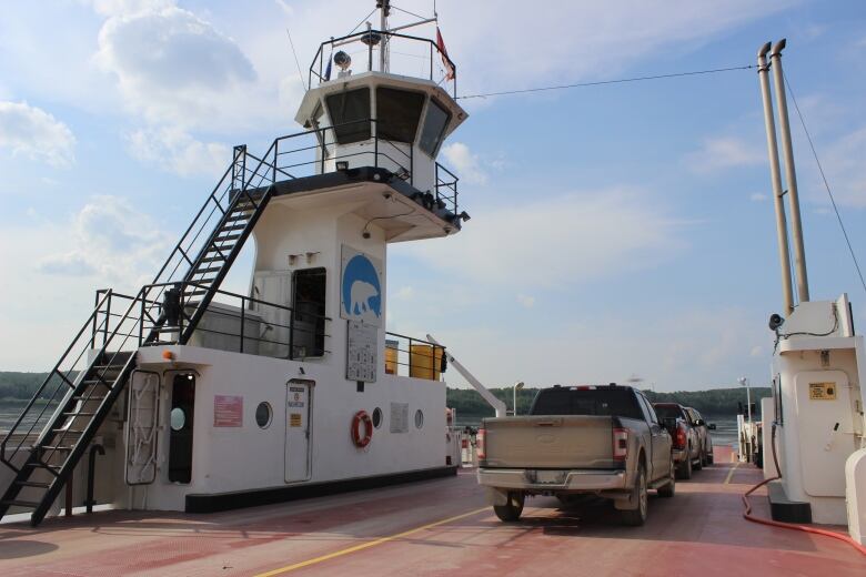 A shot of three trucks on board a red surface. An observation tower-like thing is on the left. A river can be seen in the background.