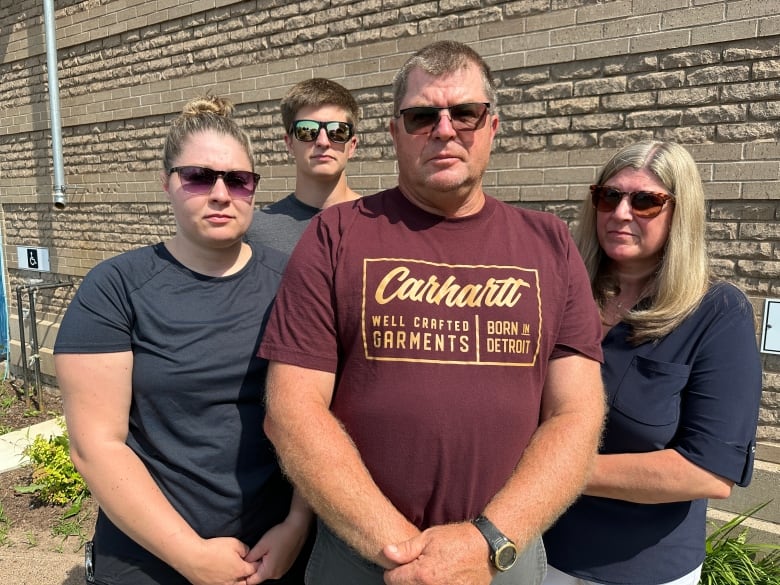 A man in a burgundy t-shirt is shown alongside his wife to his right and on his left his daughter and son.