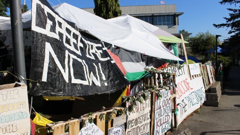 A protest camp with pro-Palestinian signage, calling for 'Ceasefire now!'