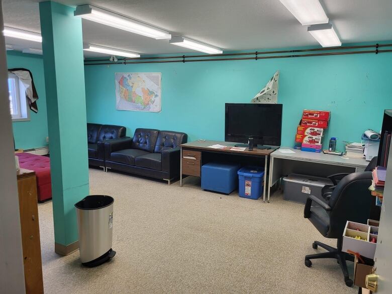 The inside of a building with a couple of couches and blue walls 