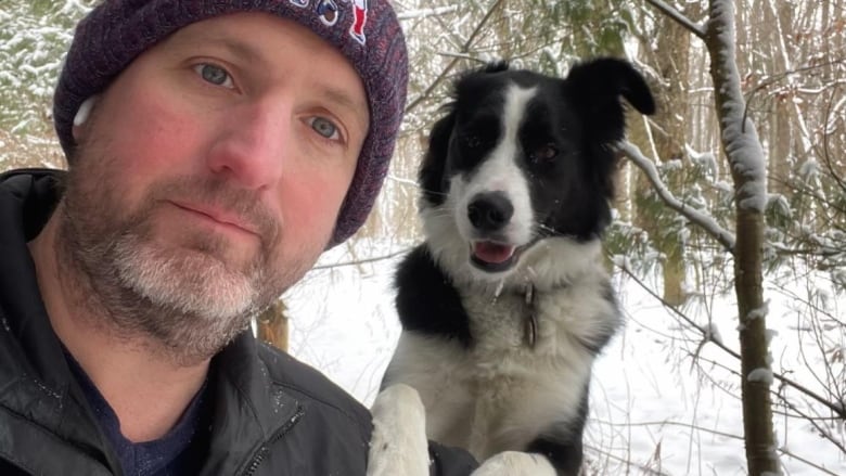 A man takes a selfie with a dog. 