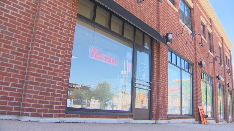 The glass of a store front is seen with a neon sign reading 'fauna' in the window