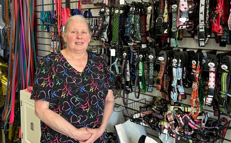 Jill Taylor standing in front of a wall of dog leashes.