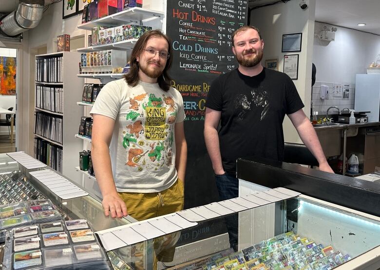 Nicholas Scurfield and Josh Brown standing behind a store counter.