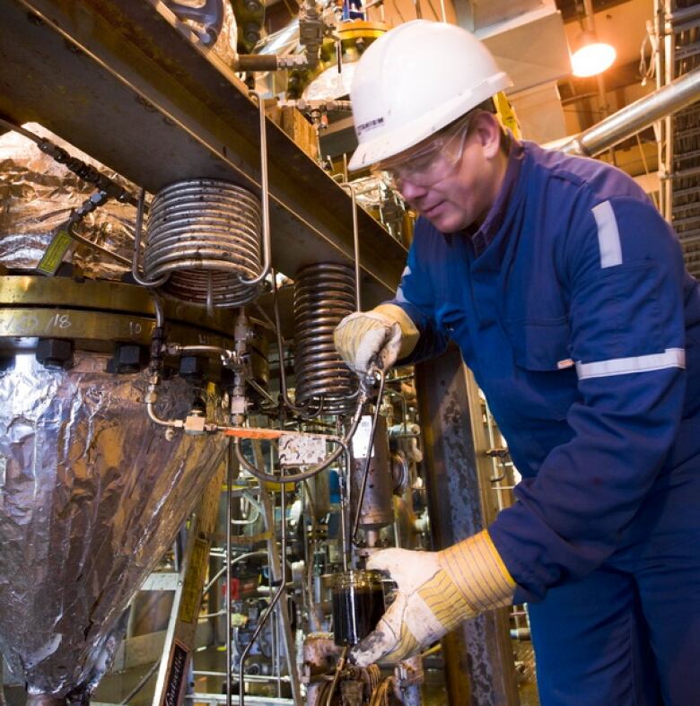 man pouring bitumen into beaker